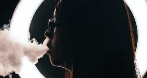 girl vaping with a ringlight in the background