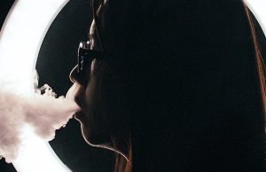girl vaping with a ringlight in the background