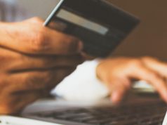 man holding his credit card to shop online