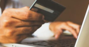 man holding his credit card to shop online