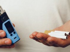 man holding cigarettes and vape