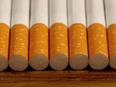 Many cigarettes stacked on wooden floor