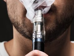 face of a young man vaping