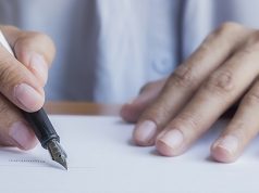 woman signing a letter
