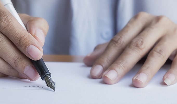 woman signing a letter